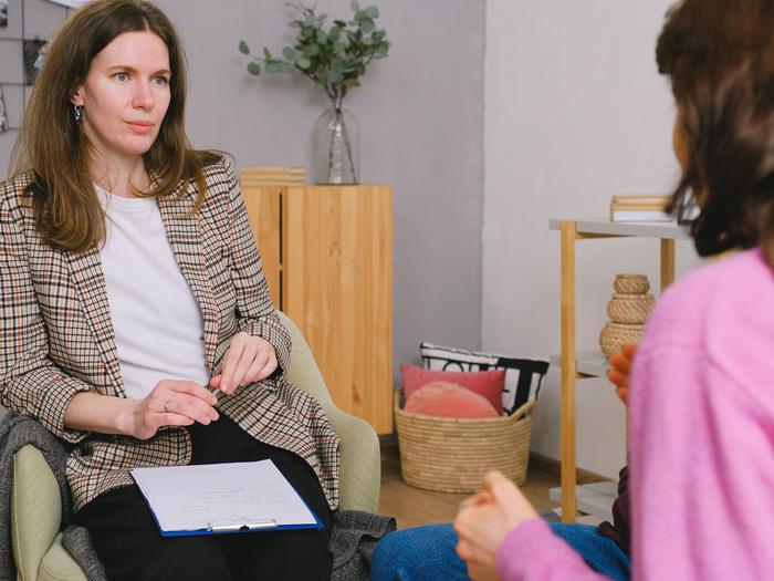 A counselor listens attentively to a client in a calm, bright office